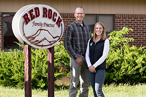 man and woman outdoors in front of a sign