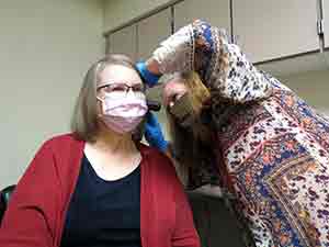 woman checking the ears of another woman