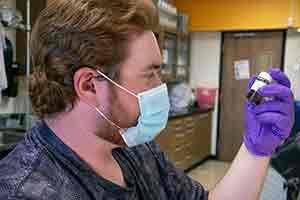 man looking at sample bottle in his hand