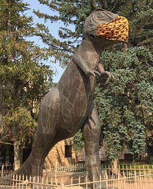 statue of a t-rex wearing a facemask