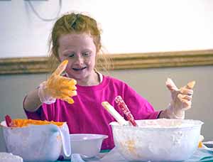 young girl with bowls of frosting