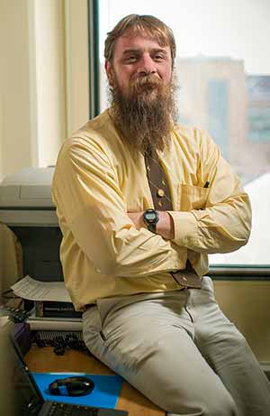 man sitting on the edge of a desk