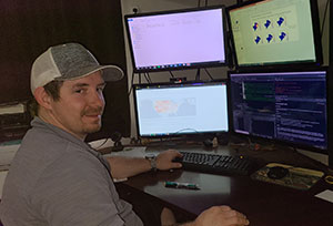 man sitting in front of computer screens