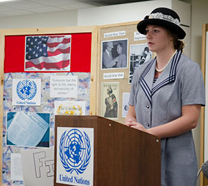 person in period clothing speaking at a podium