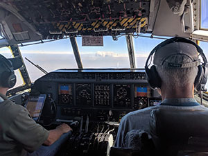 two people in plane cockpit, seen from behind