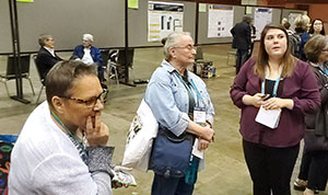 three people talking in a busy room