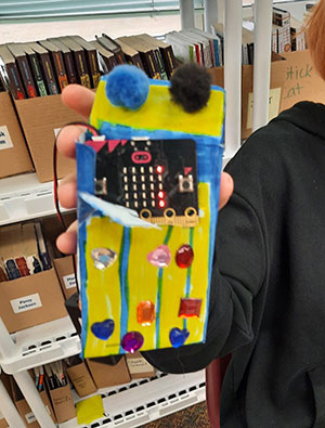 student holding a decorated pouch