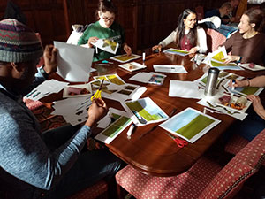 group of people around a table working with large photographs