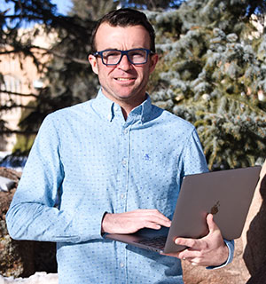 man posing with a laptop computer