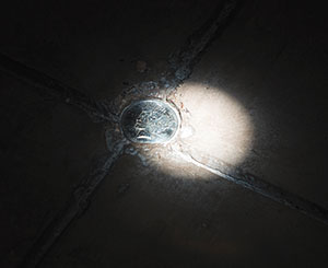 spot of sunlight on a dollar coin embedded in the floor