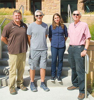 four people standing in front of a building