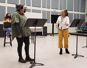 three people reading a play at a rehearsal