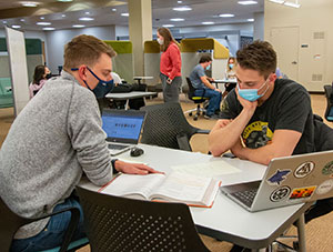 two people across a study table from each other