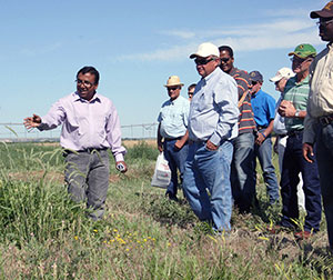 man speaking to a group of people in a field