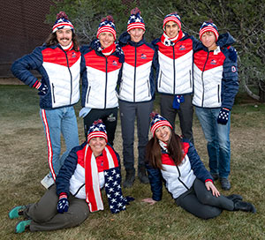 group of people in identical snow gear standing outside in the snow