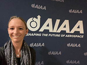 woman in front of logo-filled background