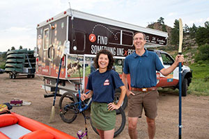 woman and man surrounded by outdoor recreation equipment