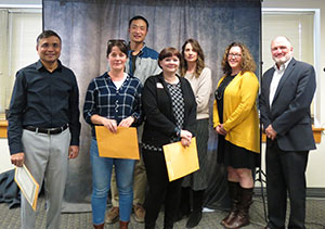 group of people holding awards