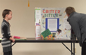 man looking at display while a young girl looks on