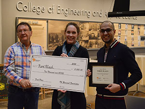 three people holding an oversized check and a certificate