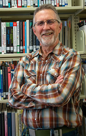 man standing in front of bookshelves