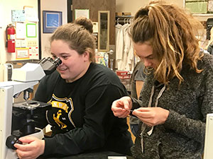 two young women using a microscope