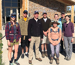 group of people standing outside a small building