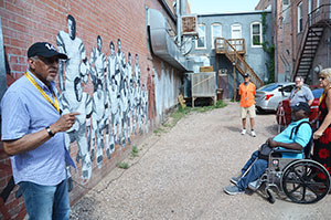 people looking at a mural on a wall