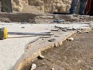 screwdriver next to layers of hardened ash being pried off