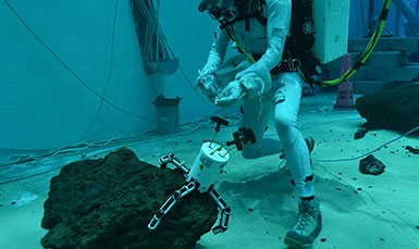 diver grabbing rock with a tooll