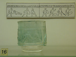 green glass cup with images embossed on it