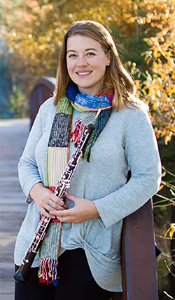 woman posing outside holding an oboe