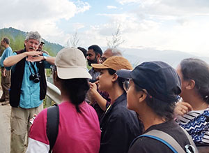 man speaking to a group of people outdoors