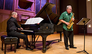 person playing piano and person playing saxophone