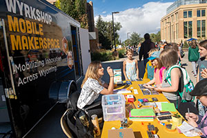 people at a table outside a van