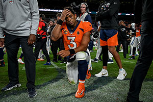 football player kneeling on the sidelines