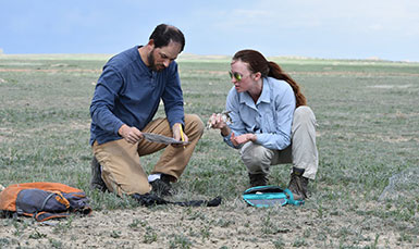 man and woman kneeling in field