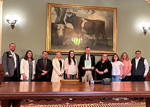 group of people standing behind a table