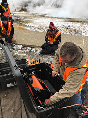 A University of Wyoming researcher led a five-year study that imaged the actual structure -- at a level of detail not previously accomplished -- of Spouter Geyser in Yellowstone National Park.  “This is the first study to actually generate images of the features; tie those images to the physical material properties of the units hosting the geysers; and observe the dynamic behavior of geysers in the subsurface versus simply on the surface,” says Brad Carr, an associate research scientist in the UW Department of Geology and Geophysics.  Carr was the corresponding and second author of a paper titled “Geophysical Imaging of the Shallow Geyser and Hydrothermal Reservoir Structures of Spouter Geyser, Yellowstone National Park: Geyser Dynamics I” that appeared Feb. 3 in the Journal of Geophysical Research Solid Earth, which publishes papers in a broad range of earth science disciplines.  Ken Sims, a UW professor of geology and geophysics, and Daniel Ciraula, a UW master’s student of geology and geophysics under Carr from 2019-2021, contributed to the paper. Ciruala, the paper’s lead author, is now a Ph.D. student conducting geothermal energy geophysics research at the University of Iceland in Reykjavik, Iceland.  Yellowstone National Park is home to about 500 geysers, which makes it the most concentrated geyser field in the world, according to the paper. Although Spouter Geyser is considered a fountain, or pool geyser, it is located about a mile away from Old Faithful, and its subsurface geology is the same as the park’s most famous geyser.  “So, by understanding how Spouter Geyser looks and operates, we get greater understanding of Old Faithful by default. Second, we show how near-surface geophysical methods can observe the dynamic behavior of geysers in real time,” Carr says. “These efforts don’t need to wait for earthquakes or bubble bursts to make arguments about the dynamic behavior of geysers.”  The study, which took place from 2017-2021, represents research results taken from active hydrogeophysical surveys -- including ground-penetrating radar, nuclear magnetic resonance, seismic refraction, electrical resistivity tomography and transient electromagnetics -- to image the subsurface geyser structure and constrain the geophysical response of the reservoir structure of Spouter Geyser.   Data acquisition was only allowed during a week or two in November and a week or two in April. These are the only short periods available for study when the park is closed to tourists, Carr says.  Previous studies relied on conceptual cartoons to understand the geyser structure and dynamics, Carr says. Over the last 20 years, geophysical efforts increased to try to gain more understanding, but few ever committed multiple geophysical methods to actually image these features on-site, he adds.  “We were the first, and I intend to continue this effort at other types of modern geysers,” Carr says. “To start, we are finishing a manuscript on similar efforts at Old Faithful and hope to get this paper published within the year.”  Carr and his research team found that, when Spouter Geyser erupts, it only loses 2 percent to 3 percent of the total water available within its geyser reservoir structure. On average, Spouter Geyser ejects 18,990 gallons of hydrothermal water during a 1.5-hour eruption. If that is only 2 percent to 3 percent of the amount of hydrothermal water in the geyser reservoir, the total amount of hydrothermal water is  949,500 gallons, he says.  To put this into context, Carr says an Olympic-size swimming pool is 50 meters in length, 25 meters in width and has a minimum depth of 2 meters, allowing the pool to hold 660,430 gallons when filled to the top. Additionally, for comparison, the average tanker truck driving on Interstate 80 holds about 11,000 gallons of liquid.  “Therefore, the subsurface geyser reservoir structure for Spouter Geyser holds 1.5 Olympic swimming pools’ worth of hydrothermal water and ejects about two tanker trucks’ worth of hydrothermal fluids over 1.5 hours,” Carr says.  According to the paper, the knowledge of subsurface geyser structure and geyser eruption dynamics can be applied to other processes, including hydrothermal explosions and volcanic eruption dynamics, in Yellowstone National Park.  “These methods could be applied to other geysers to understand better the differences in geyser eruption behavior,” he says. “Additionally, our findings show potential for using time-lapse electrical resistivity measurements as a monitoring tool for the hydrothermal explosion hazards within Yellowstone National Park and the sustainable development of geothermal reservoirs globally.”   The work was funded by grants from UW’s Near-Surface Geophysics Instrument Center, the UW Foundation and a UW Faculty Grant in Aid.  A companion paper titled “Time-Lapse Geophysical Investigation of Geyser Dynamics at Spouter Geyser, Yellowstone National Park: Geyser Dynamics II” was published Feb. 5 in the same journal.  “It was necessary to establish the geyser structure within the glacial till of Upper Geyser Basin first, since no one had ever done this detailed level of geophysical imaging at a geyser before,” Carr explains. “After establishing the geyser structure, the second paper discusses how we used geophysical methods to monitor the dynamics of Spouter Geyser.”  The dynamics of the geyser involve the fluid and vapor phase (steam and gases) interactions within the geyser reservoir structure. Additionally, the research team looked at the outflow fluid temperature data over the past 23 years to show how the eruption times of Spouter Geyser are staying nearly constant at 1.5 hours. However, the recharge times -- the times when Spouter isn’t erupting -- are shortening at a rate of 6.6 minutes per year, Carr says.