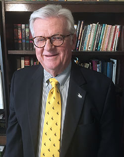 man in front of a bookshelf