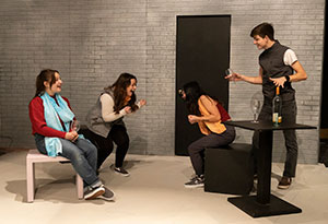 three women and man on stage rehearsing