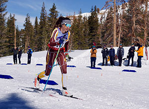 woman Nordic skiing with people looking on