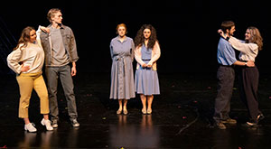 six people rehearsing on a stage