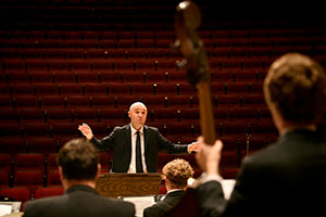 man conducting musicians