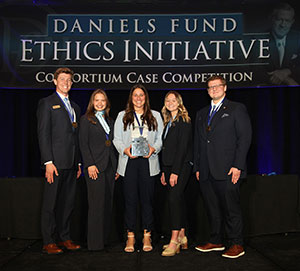 five people posing with an award