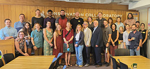 large group of people posing at the end of a room