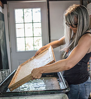 woman working with paper-making frame