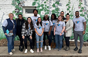 group of people posing in front of an outdoor mural of flowers