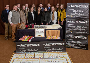 people posing behind a table with awards on it