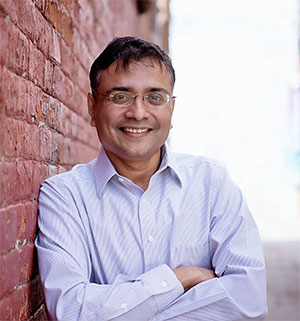 man leaning against a brick wall